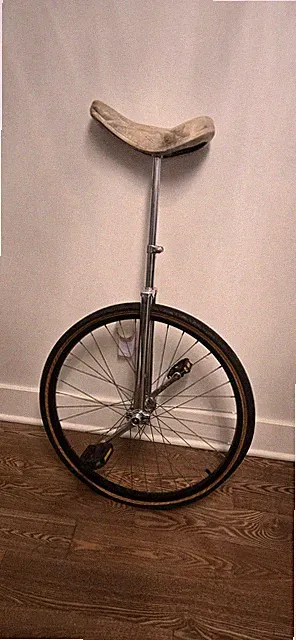 Silver Frame Unicycle with Black Tire and Beige Seat